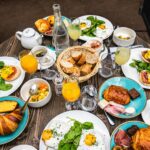 Savor the flavors of a classic Parisian brunch featuring croissants, eggs Benedict, and fresh juice on a wooden table.
